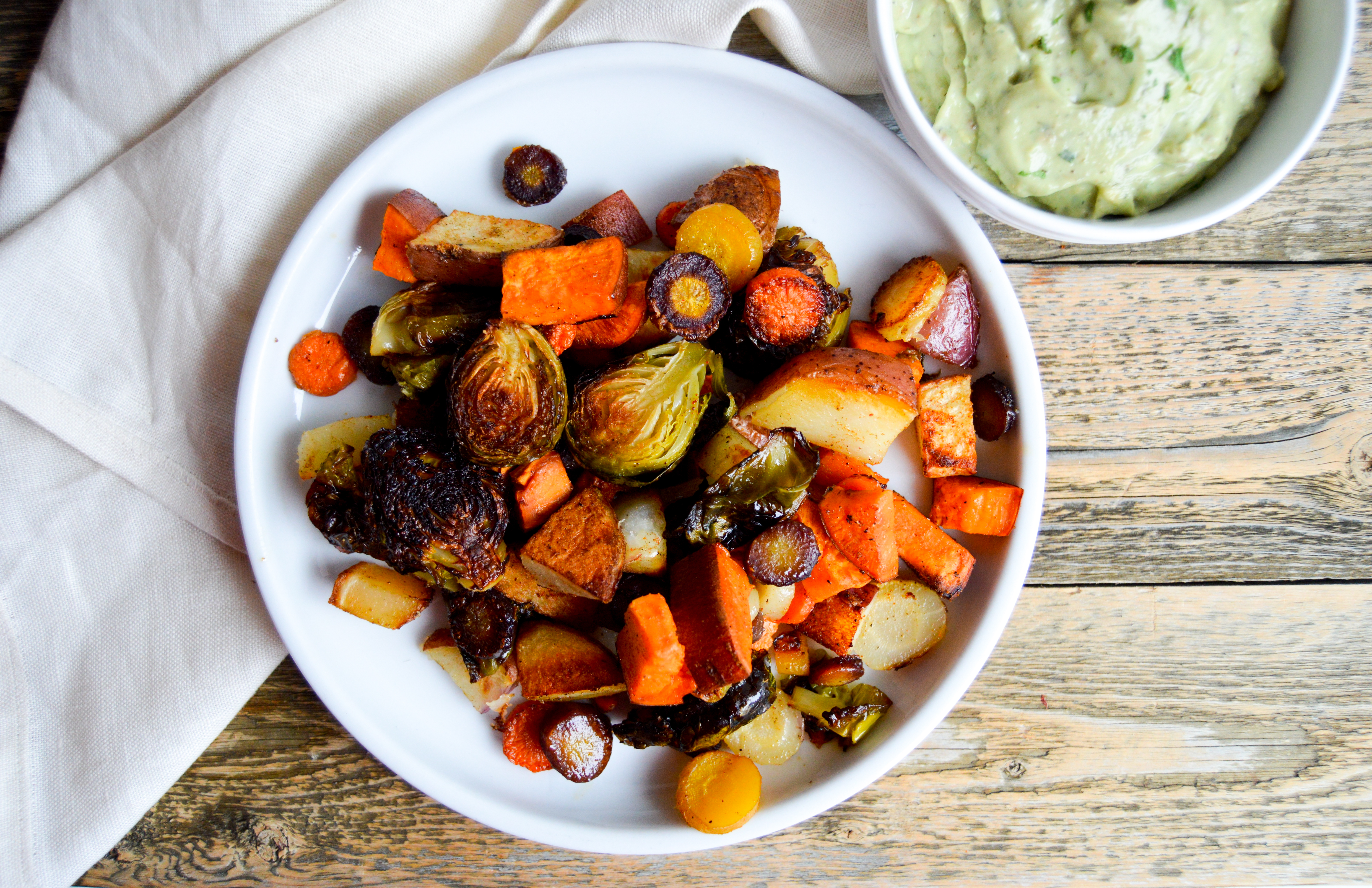 Recipe for baking hearty sheet pan veggies and avocado ranch dip recipe. Vegetable filled dinner idea for a healthy meal. Corn oil and avocado substitutions. Rainbow carrots, brussels sprouts, sweet potato, and red potato veggies baked with corn oil and seasonings. Delicious, easy, healthy dinner dish.