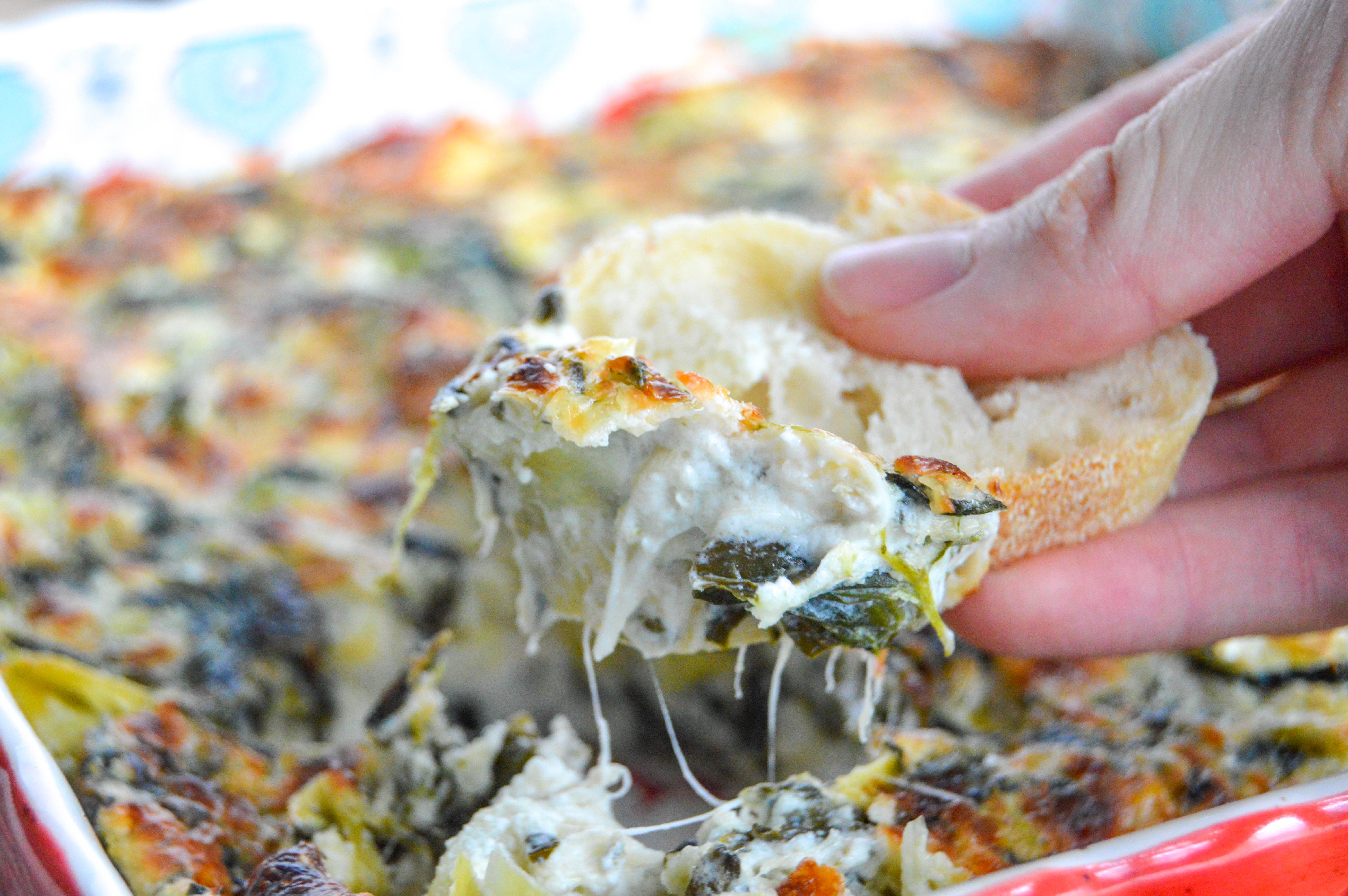 Cheesy spinach artichoke dip. Baked in the oven. Served with baguette slices.