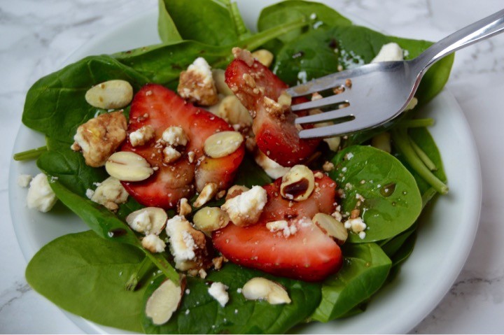 Strawberry Spinach Salad with sliced almonds, feta cheese, and a Honey Balsamic Vinaigrette Dressing | Easy Easter dinner menu for the family. Fresh, springtime dinner with vegetable lasagna main course, strawberry spinach salad, rolls, + milkshake dessert.