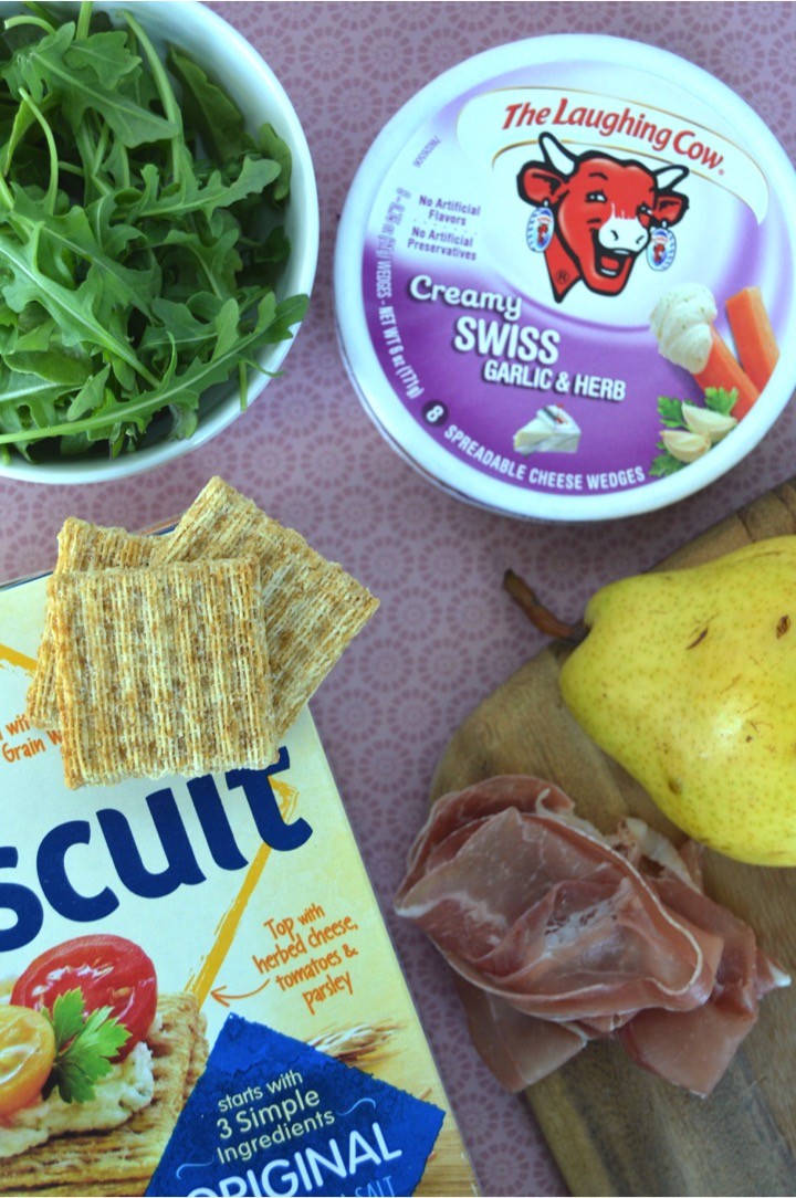 Ingredients list of fancy cheese and crackers recipe for the foodie with TRISCUIT Crackers, creamy cheese, prosciutto, pear, and arugula leaves. Perfect appetizer or snack.