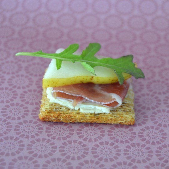 Step 4 - Top with arugula. Fancy cheese and crackers recipe for the foodie with TRISCUIT Crackers, creamy cheese spread, prosciutto, pear, and arugula leaves. Perfect appetizer or snack. Delicious food to make for a party or just for fun with the kids. 
