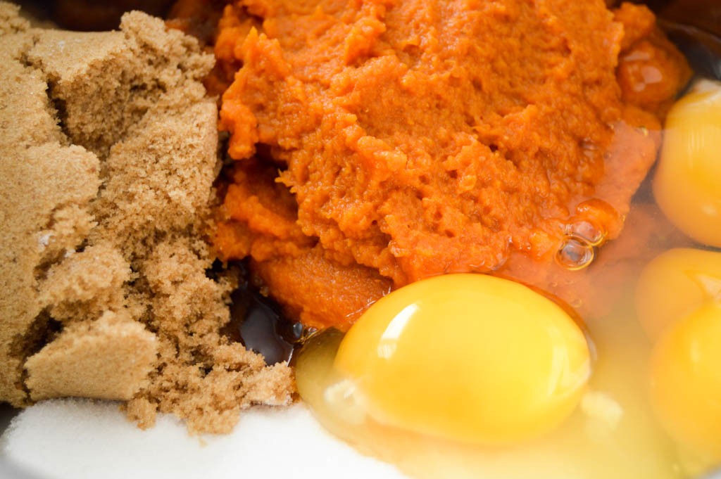 Pumpkin, eggs, sugar, brown sugar, and other ingredients for making moist pumpkin muffins