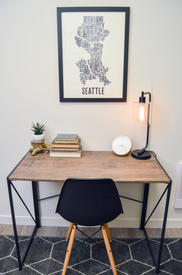 Home Staging: home office in a modern industrial feel. desk and midcentury modern chair with black edison bulb table lamp and masculine style.