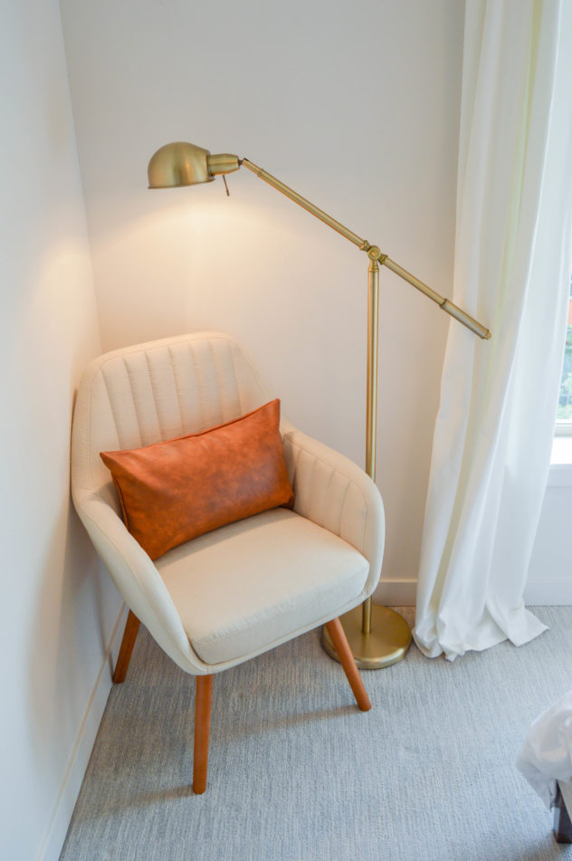 Home Staging: bedroom accent chair with leather pillow and floor lamp