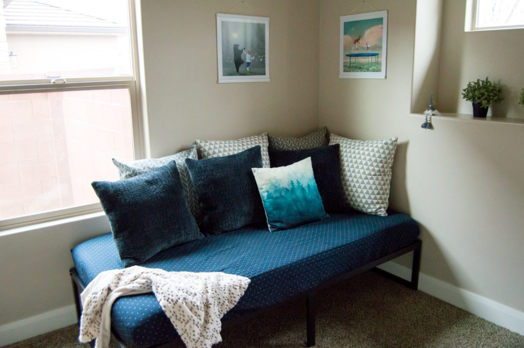 bed set up like a couch with cute pillows in kids playroom nursery