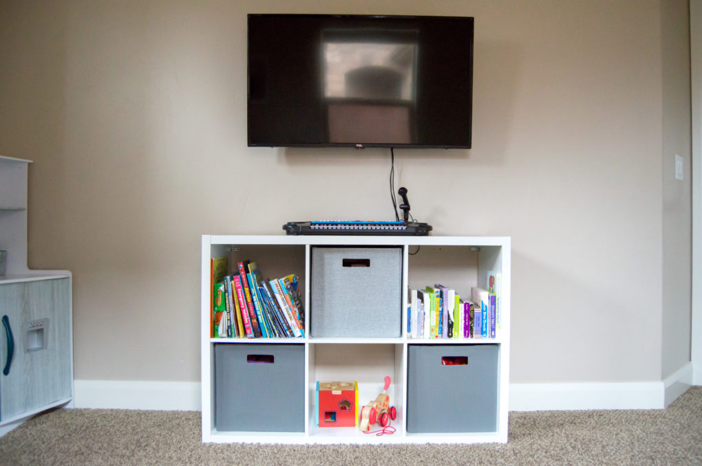 cube storage shelf for organizing kids books and toys with a tv station in kids playroom and nursery
