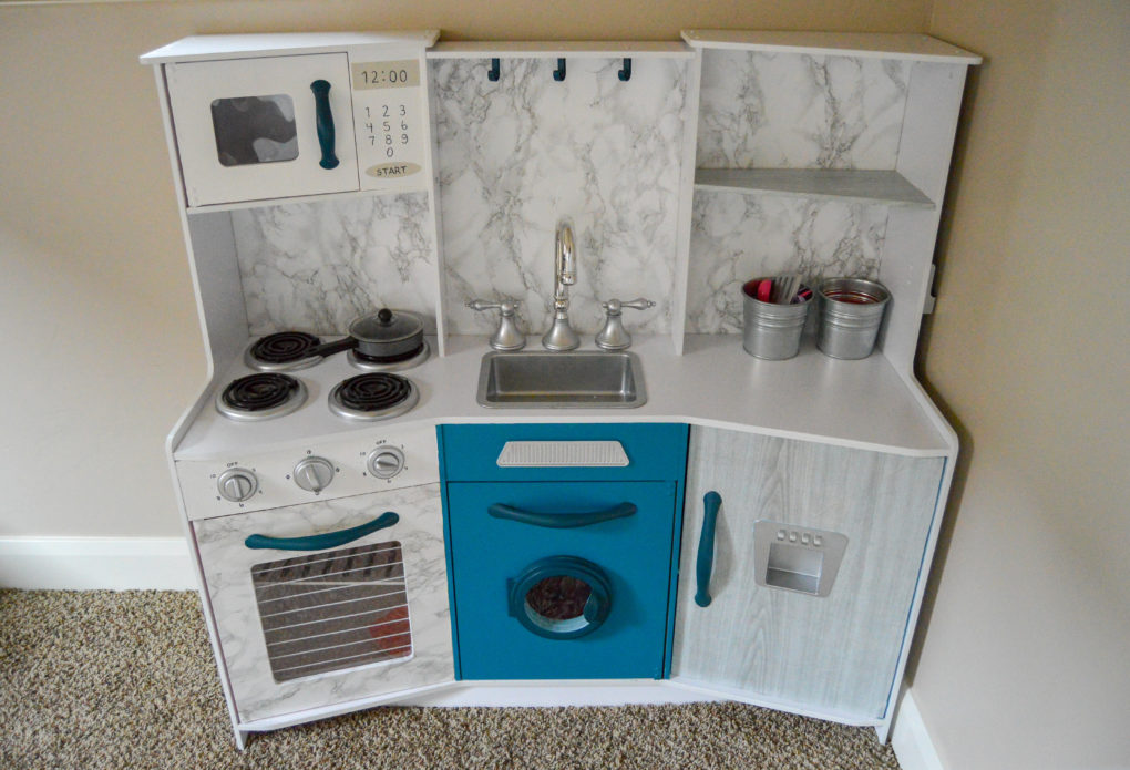 The after. How to do a play kitchen makeover. Paint, wallpaper, and revive an old play kitchen to make it look cute and modern. Plus our kids' playroom.