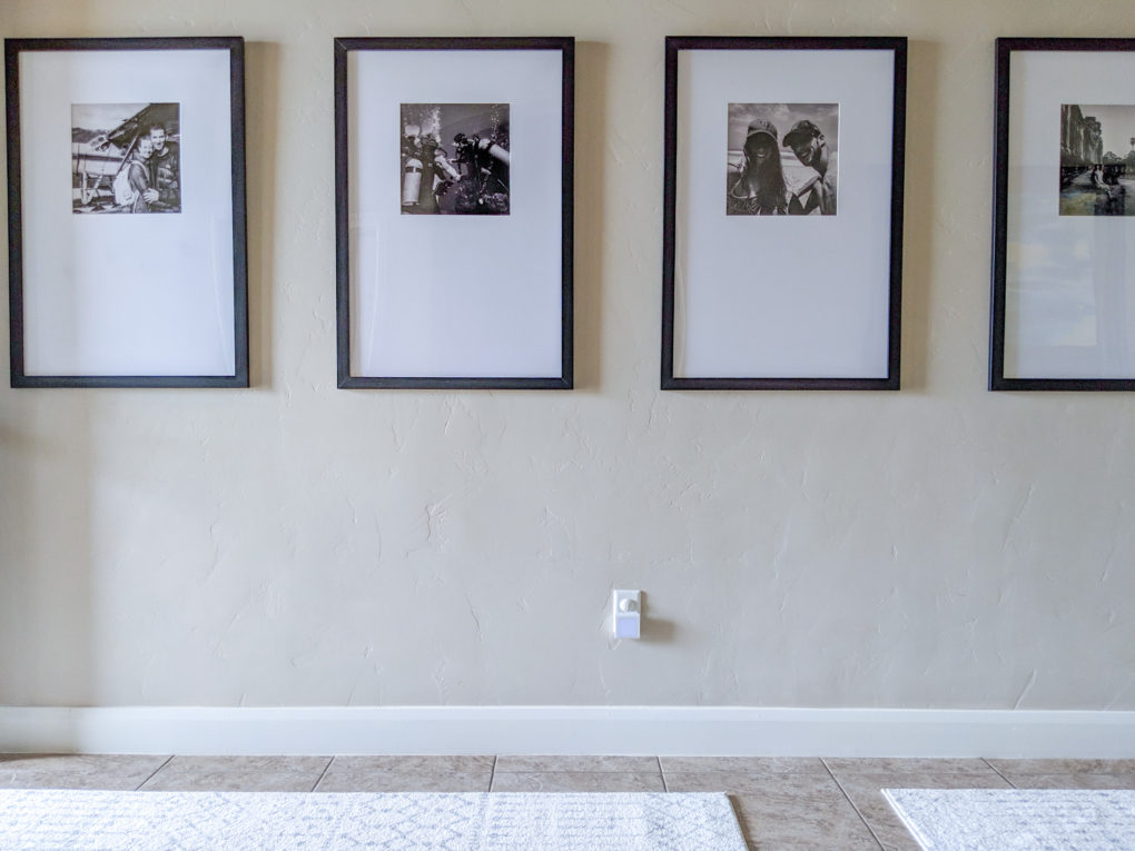 Travel gallery wall in long entryway with oversized frames.