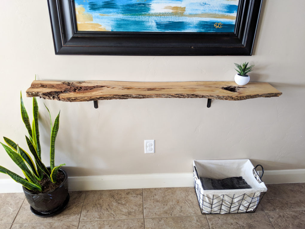 How to make a DIY live edge wood shelf from a wood slab. The sanding, protective coat, and brackets  used to secure it. Great hallway shelf or console table.