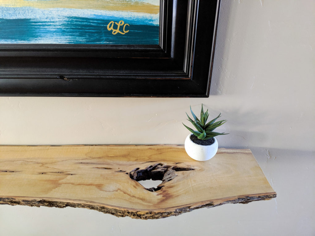 Cool knot hole in wood shelf. How to make a DIY live edge wood shelf from a wood slab. The sanding, protective coat, and brackets  used to secure it. Great hallway shelf or console table.
