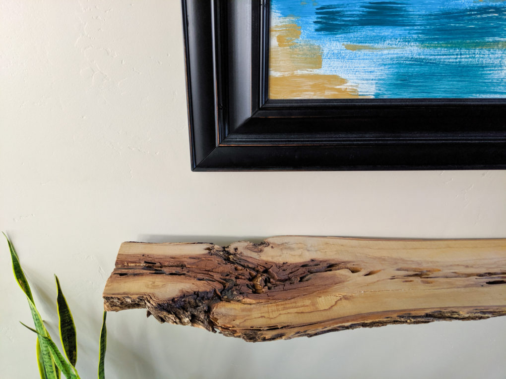 Cool character on wood shelf. How to make a DIY live edge wood shelf from a wood slab. The sanding, protective coat, and brackets  used to secure it. Great hallway shelf or console table.